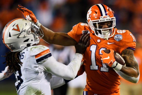 Clemson safety Isaiah Simmons (11) pushes past Virginia quarterback Bryce Perkins (3) after intercepting the ball during the ACC Championship game at the Bank of America Stadium Saturday, Dec. 7, 2019.