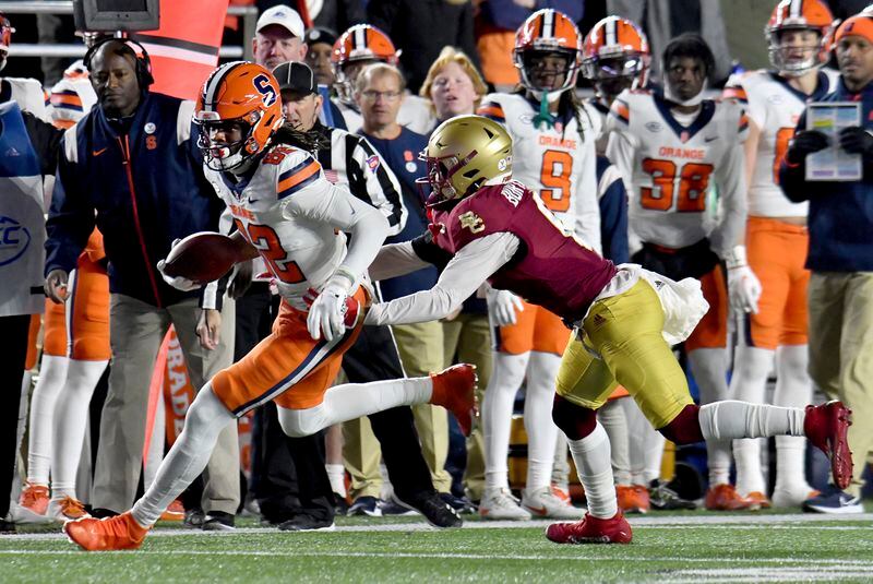 Syracuse wide receiver Damien Alford, left, is chased down the sideline and tackled by Boston College's CJ Burton, right, during the first half of an NCAA college football game, Saturday, Nov. 26, 2022, in Boston. (AP Photo/Mark Stockwell)